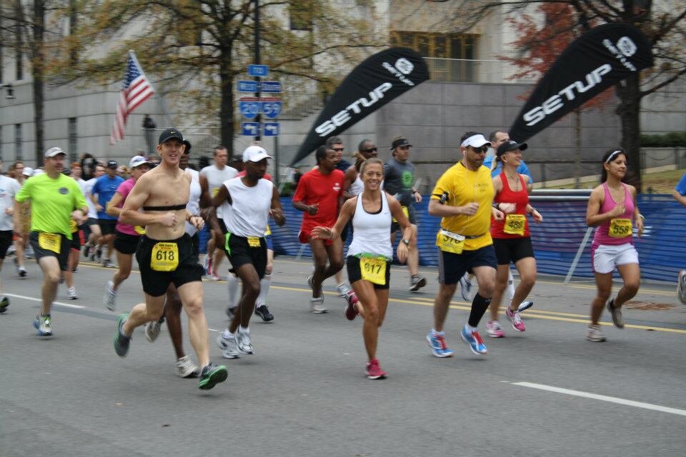 Smiling as they pass the cheering fans along the crowed streets, Ashley Harbin, center, and her husband Jeremy, left, run the Reuben Studdard half marathon in Birmingham