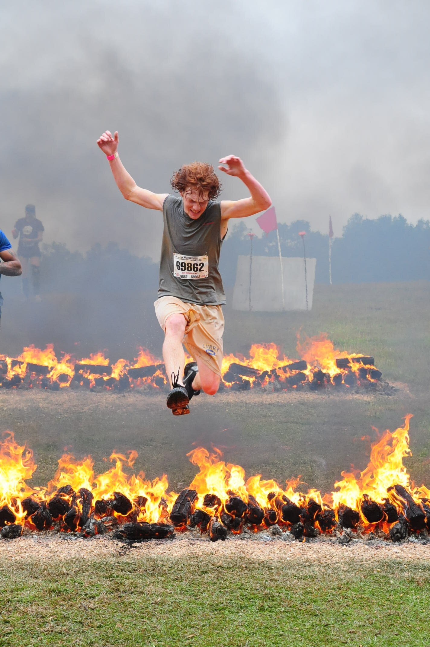 The lanes of fire are some of the last obstacles the warriors must leap. My son Brett bounds easily over the fire and heads for the last pit of mud before reaching the finish line. 
